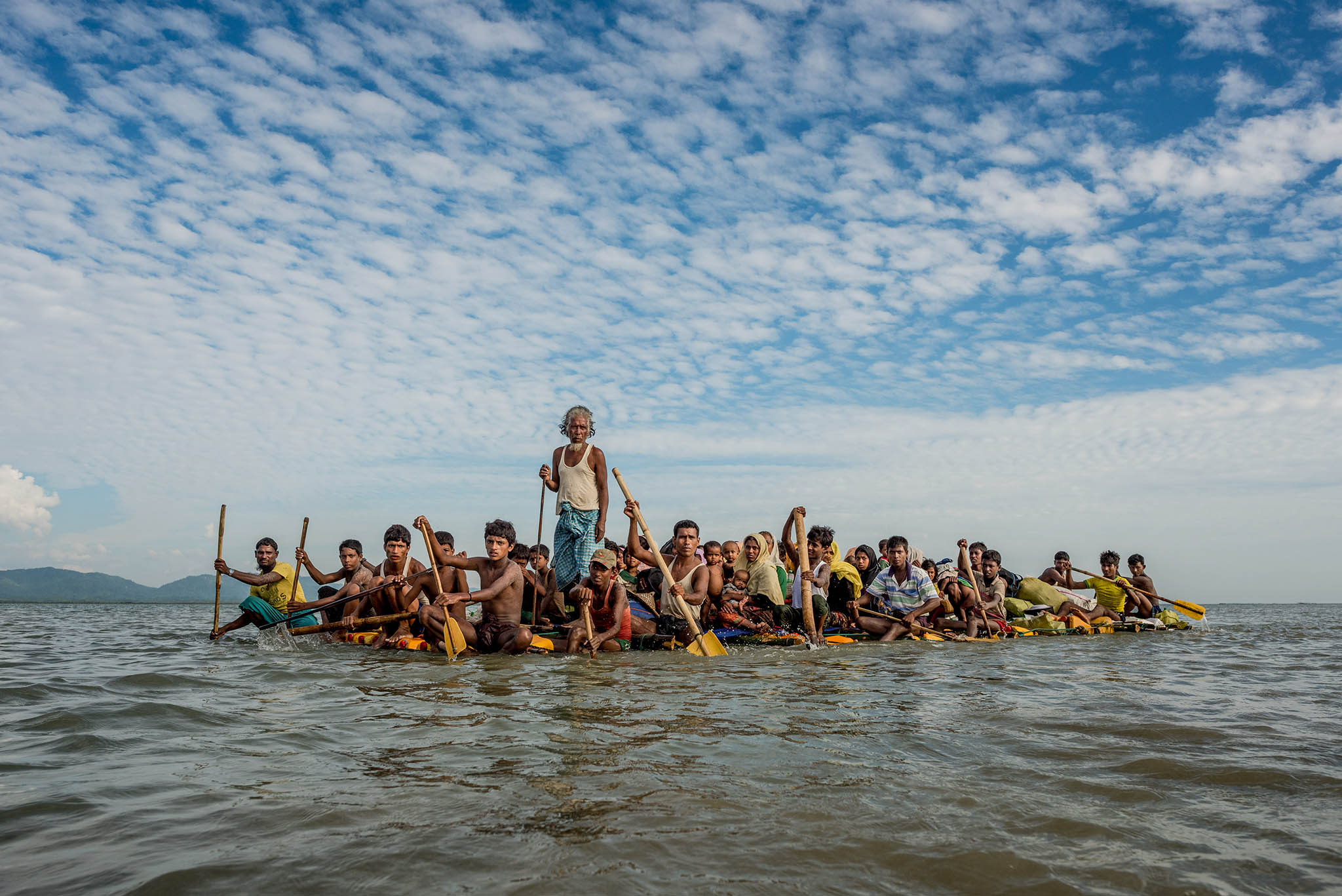 Rohingya refugees fleeing genocide use a makeshift raft to cross the Naf River from Myanmar into Bangladesh on Nov. 11, 2017. (Tomas Munita/The New York Times)