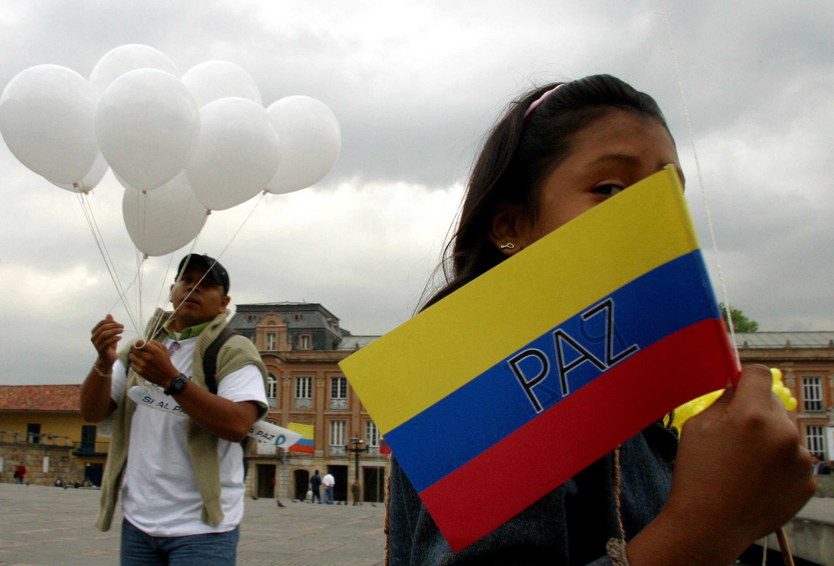 A young girl holds a Colombian flag that reads "Peace" in front of the Congress building where Salvatore Mancusso, paramilitary leader of the supreme commander of the United Self-Defense Forces was speakingM Wednesday, July 28, 2004 in Bogota, Wednesday, July 28, 2004. Mancuso addressed lawmakers for the first time about the peace process between the AUC and the Colombian government. (Scott Dalton/The New York Times) 