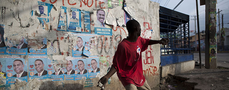 A protester hurls a rock at United Nations peacekeepers outside the electoral board offices in Port-au-Prince, Haiti, on Dec. 8, 2010. Angry protesters torched the headquarters of the government-backed presidential candidate and blocked streets with rubble from earthquake-destroyed buildings hours after the late-night release of preliminary election results triggered violence and new questions about vote rigging.