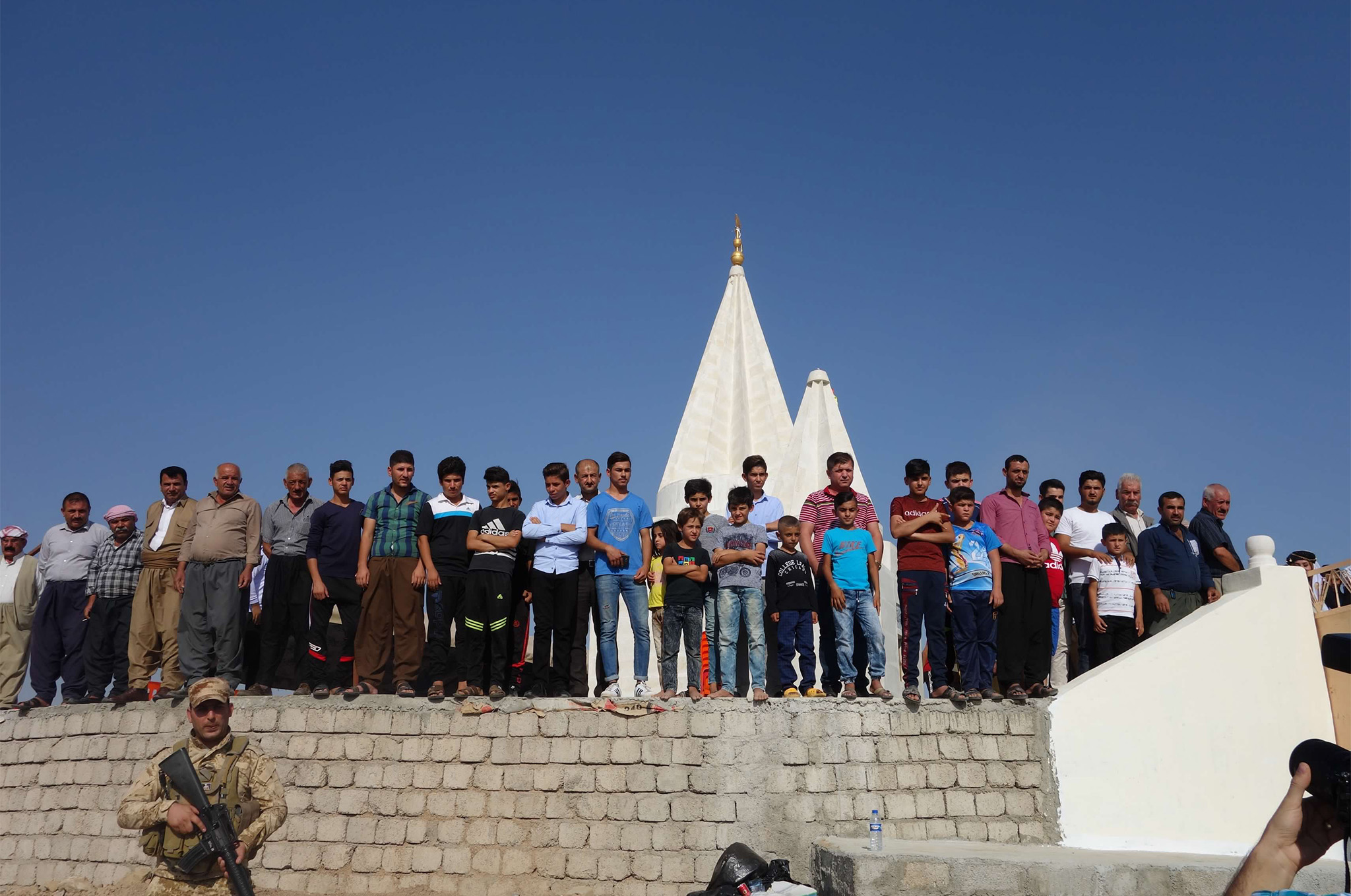 Yazidi men and boys gather at the ribbon-cutting ceremony for a reconstructed Yazidi temple in Khoshaba, Iraq, September 2017.