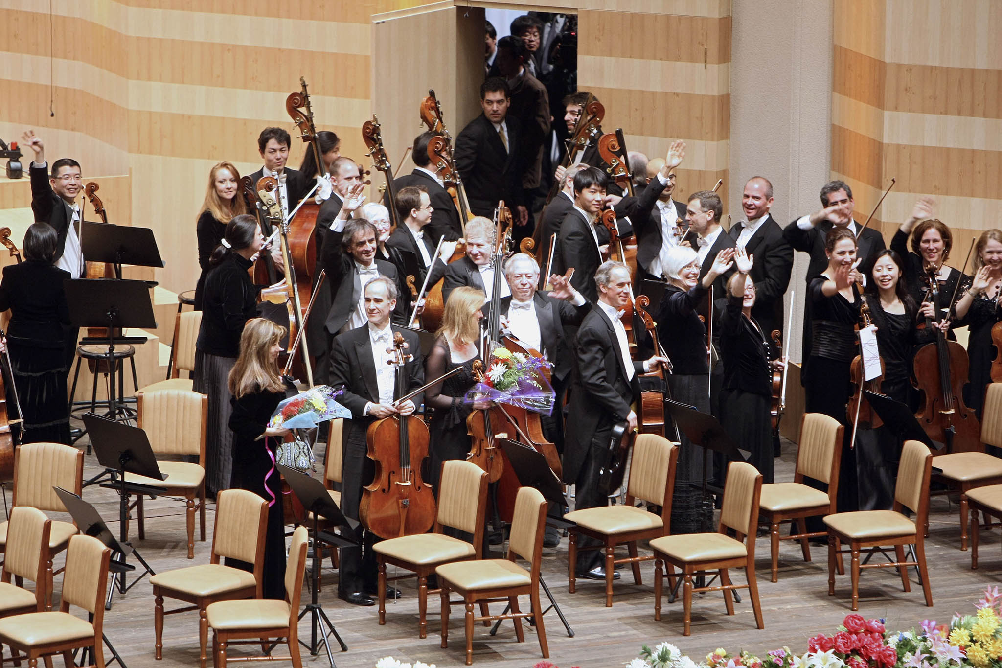 Members of the New York Philharmonic waved to the audience as they left the stage following their historic concert in Pyongyang on Feb. 26, 2008. (Chang W. Lee/The New York Times)
