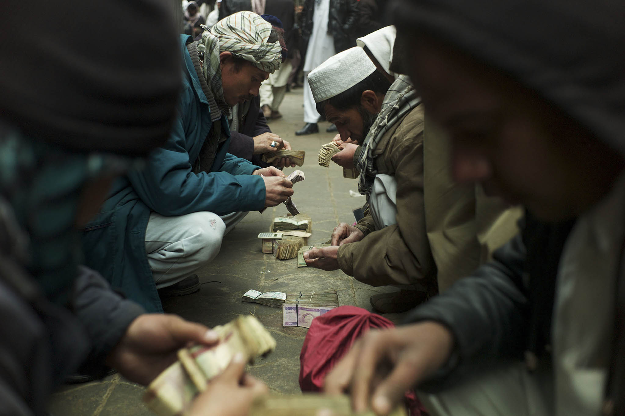 Men negotiate money exchanges at a market in Kabul, on Jan. 29, 2011. (Michael Kamber/The New York Times)