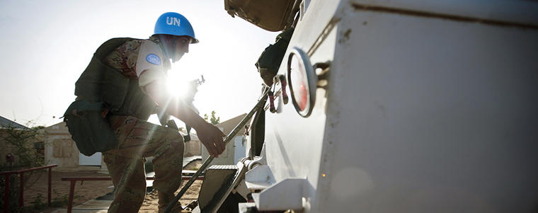 An Egyptian peacekeeper with the African Union-United Nations Hybrid Operation in Darfur (UNAMID) boards an armoured personal carrier (APC) before an evening patrol to Hali Mussa.  The 860 troops of UNAMID’s Egyptian contingent are based in Um Kadada, North Darfur, and are tasked with providing security in the area which since 2010, has been free of clashes and camps for those displaced by unrest.