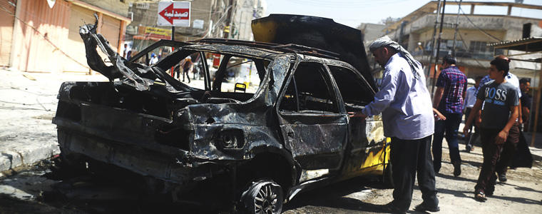 A damaged car after a bombing attack in Baghdad. 