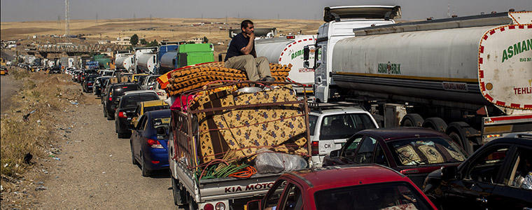 People leaving areas controlled by the Islamic State in Iraq and Syria wait to clear the Khazer checkpoint between Mosul and Erbil in Iraq, June 14, 2014. Photo Credit: The New York Times/ Bryan Denton