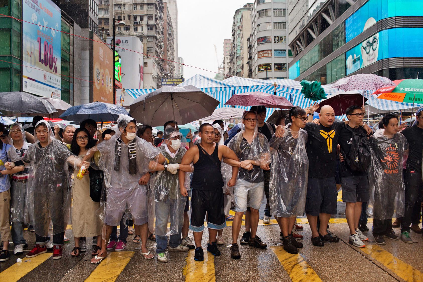 Pro-democracy protesters stand in a formation after coming under assault in the Mong Kok neighborhood of Hong Kong, Oct. 3, 2014. Demonstrators in two parts of Hong Kong came under attack on Friday from men seeking to break apart their encampments, surrounding them and tearing down their tents.