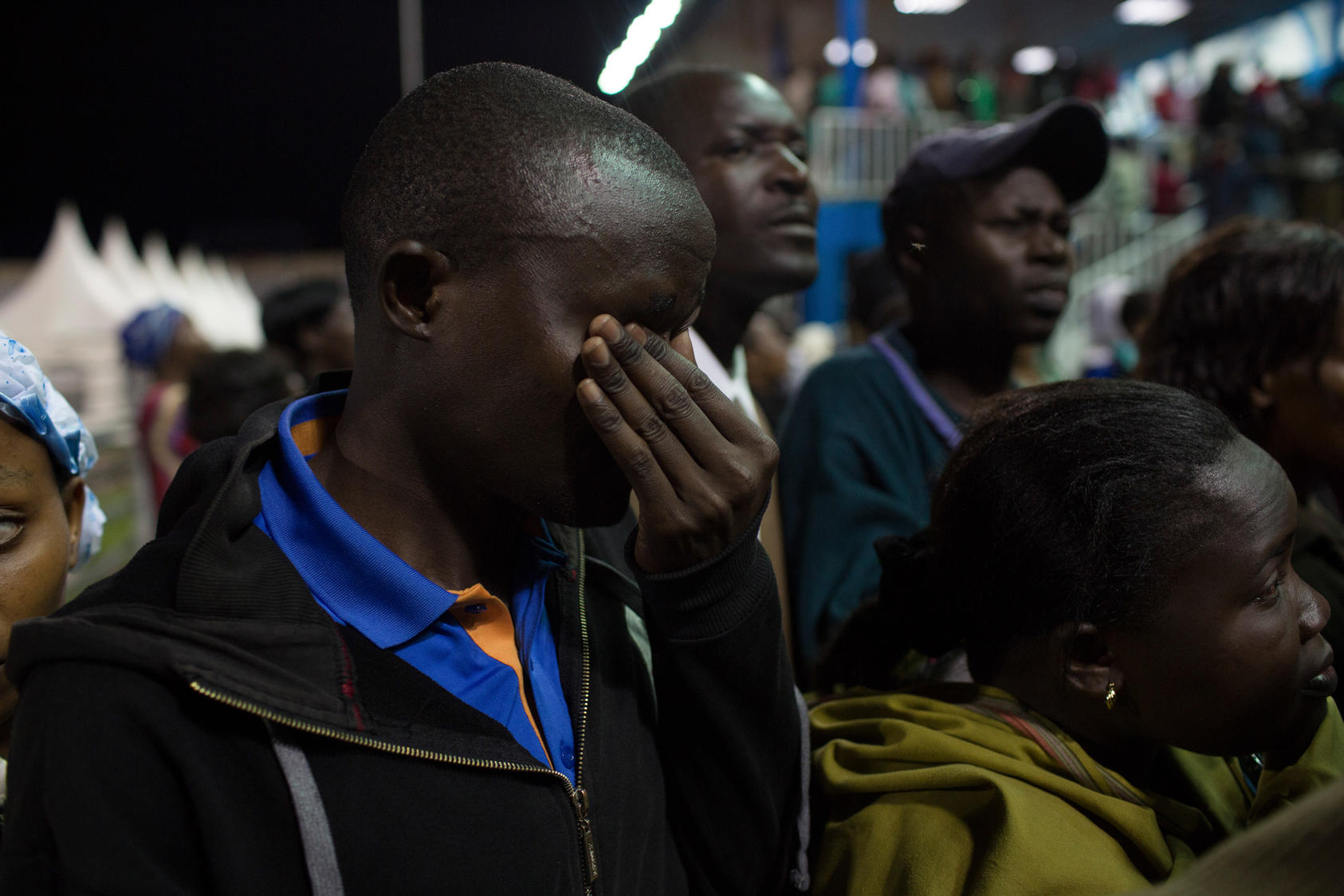 A family member wipes tears from his eyes after he spots his sister Eunice in the stadium which was being used as a crisis center after an attack at Garissa University College in Nairobi, Kenya, April 4, 2015. Scores of families were waiting on Saturday to identify relatives who died on Thursday when armed men belonging to the Shabab stormed a university campus and killed nearly 150 students.