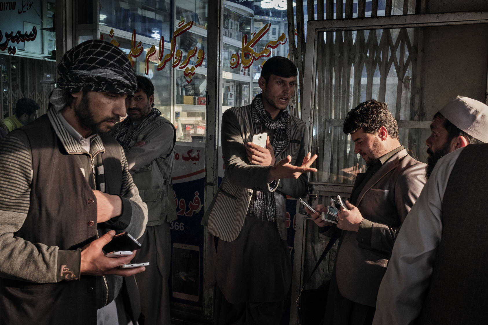 Afghans buy and sell used and new mobile phones, SIM cards and phone credit cards at a market in Kabul, Afghanistan, March 31, 2016. The local telecommunications industry was a rare economic bright spot, but losses are now mounting as new taxes are imposed and a dwindling pool of customers as American troops and foreign contractors leave. 