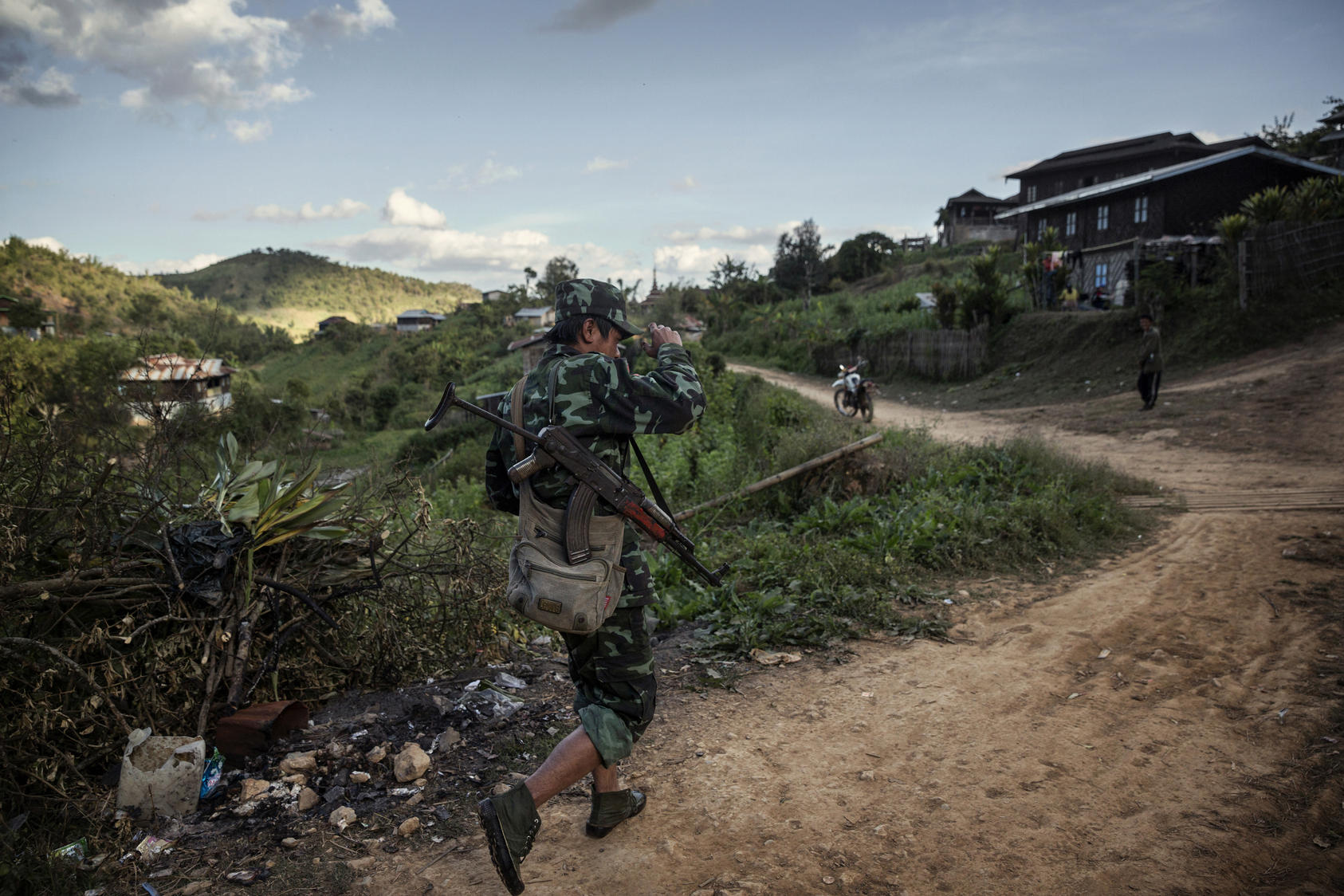 A Shan State Army - South rebel soldier walks through Bang Laem Village, Shan State, Myanmar, an area where poppy farming has flourished, Dec. 7, 2014. Growing opium poppies is illegal in Myanmar, but small-scale farmers see it is a relatively low-risk cash crop. 
