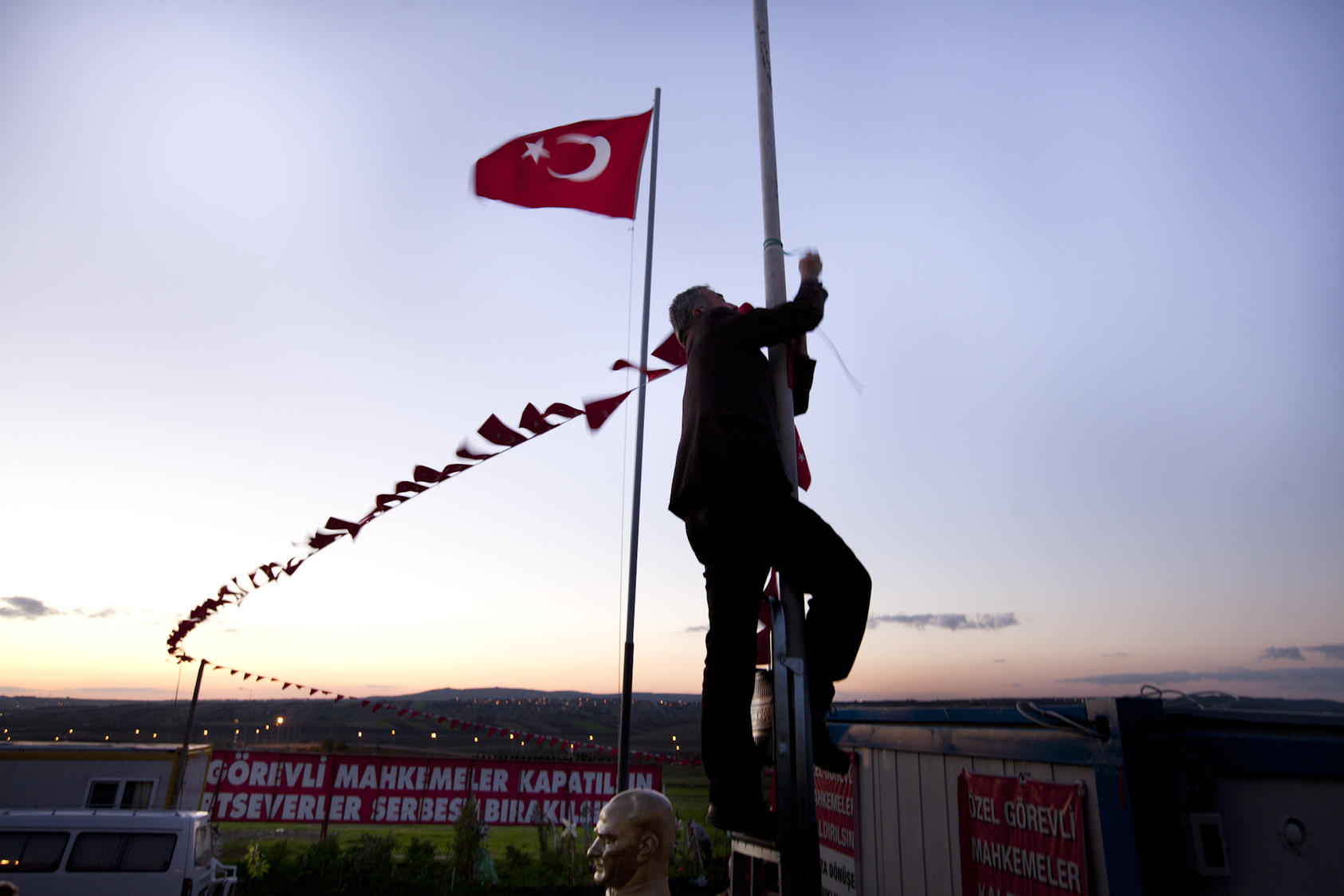 A man ties flags around a pole at a protest camp outside a prison and courthouse in Silivri, Turkey, Nov. 8, 2012. Secular protesters have set up a camp to protest the trial of hundreds of military officers charged with plotting to overthrow the Islamic-rooted government.