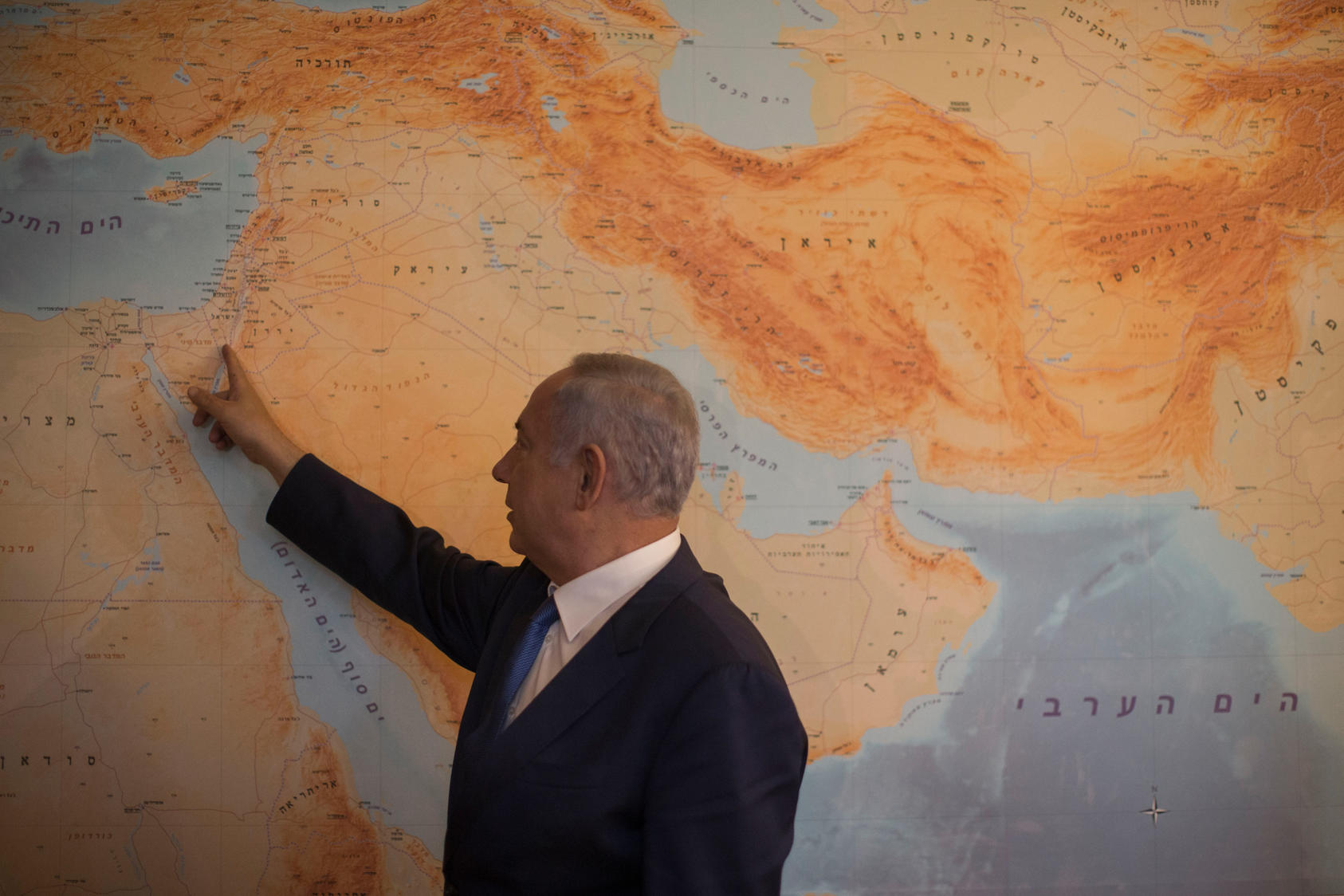 Prime Minister Benjamin Netanyahu with a floor-to-ceiling map that has Israel at its center, in his office in Jerusalem, July 2016. Photo Courtesy of The New York Times/Uriel Sinai
