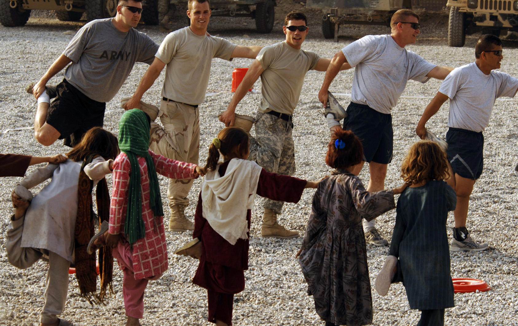 U.S. Army and Air Force personnel and local children stretch before a soccer game at the Nangarhar Provincial Reconstruction Team Forward Operating Base in Jalalabad, Afghanistan.