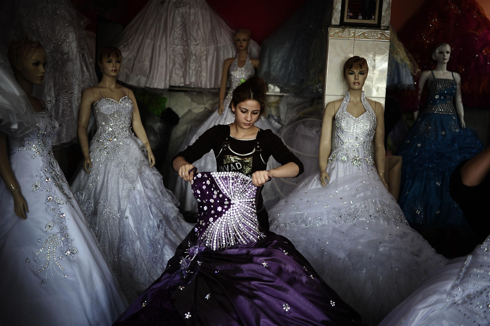 A woman works in a shop that rents wedding dresses in the Sadr City neighborhood of Baghdad.