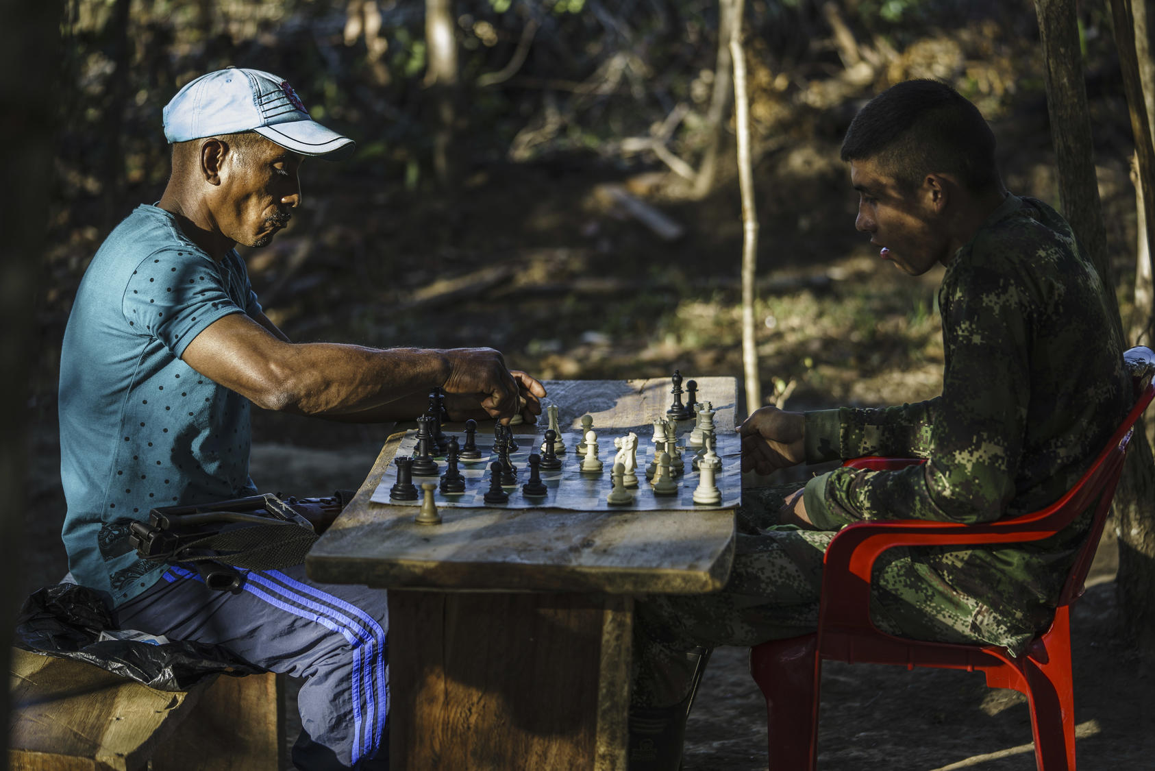 FARC members play chess in one of the zones set up to transition the former rebels back to civilian life, near La Paz, Colombia, Feb. 1, 2017. As the peace process moves ahead, mixed feelings in towns like La Paz are clear evidence of lingering divisions and bitter memories of the conflict. (Federico Rios Escobar/The New York Times)