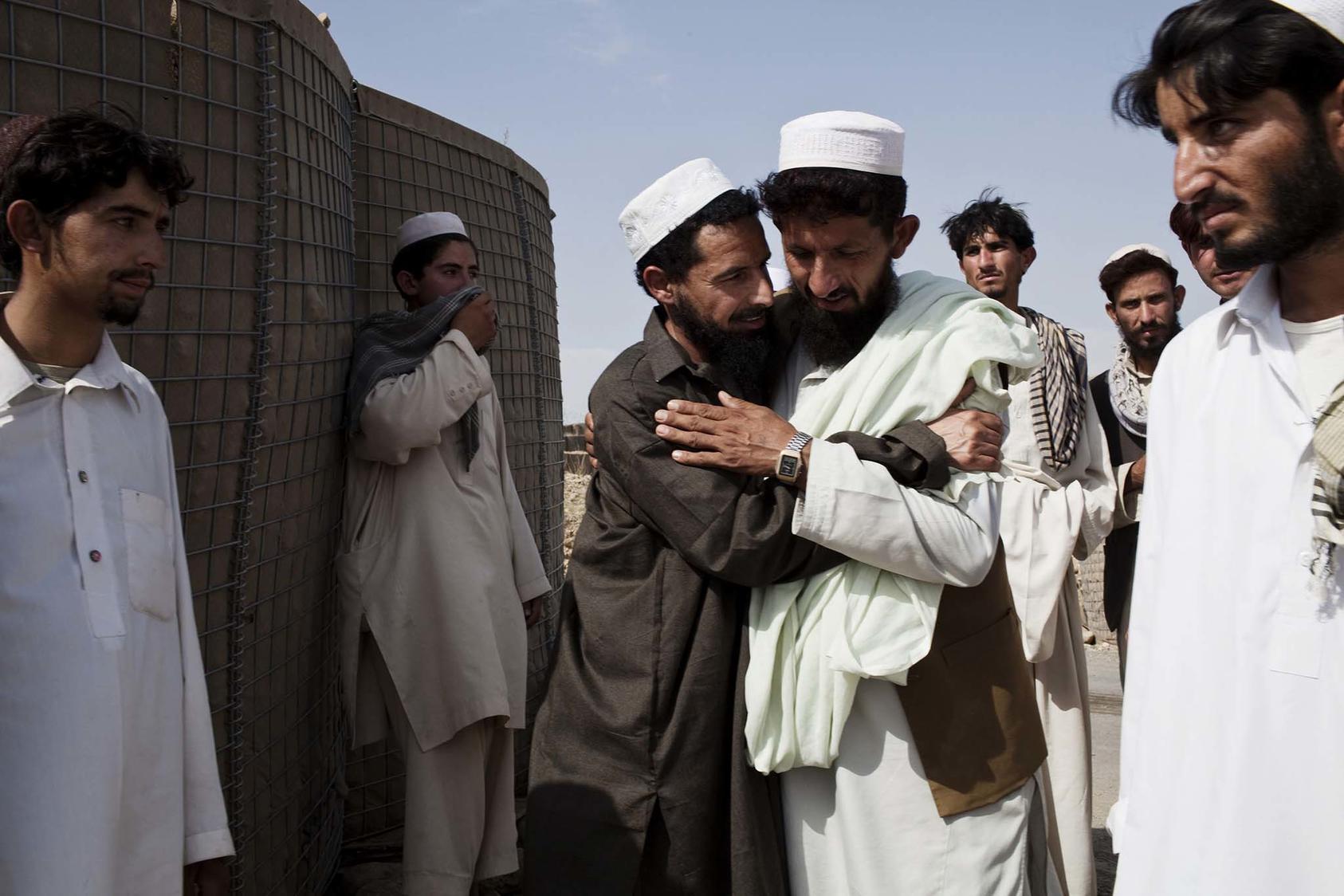 A former detainee is greeted by friends and relatives after his release from a shura at the Operational Coordination Center Provincial in the Khost Province of Afghanistan. (Photo Credit: Adam Ferguson/New York Times)
