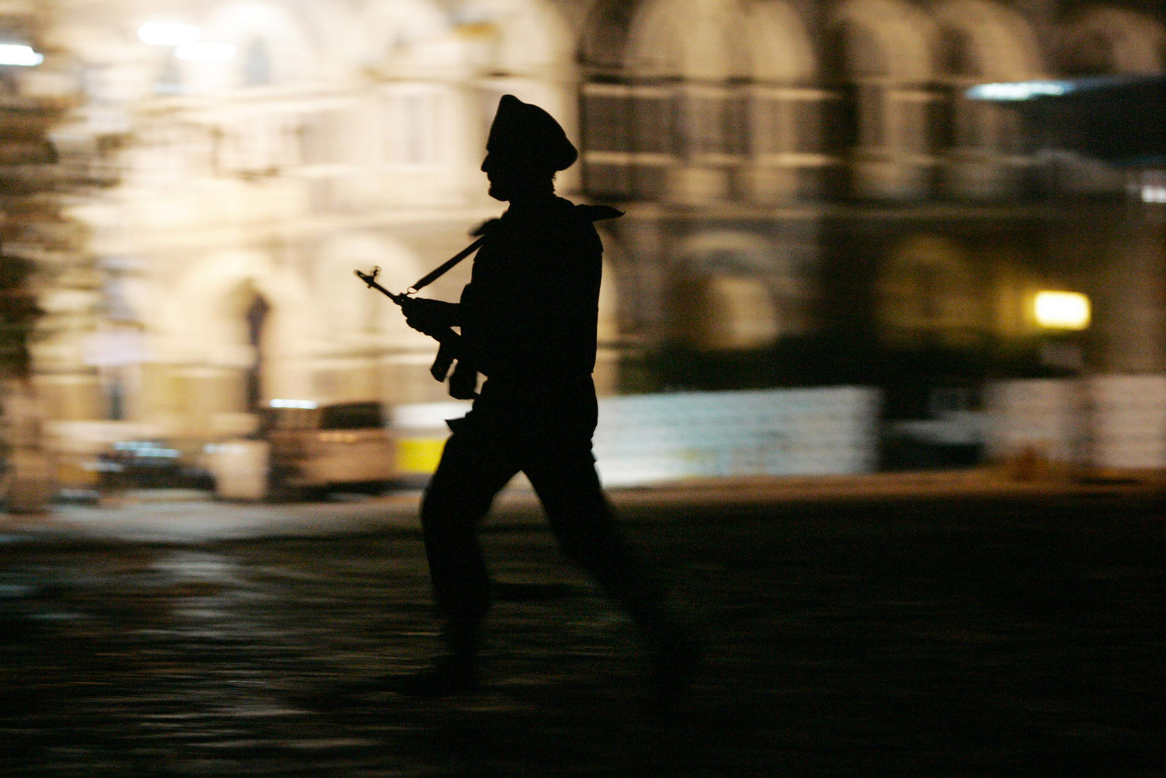 A soldier runs across the courtyard in front of the Taj Mahal Palace & Tower hotel in Mumbai, India, on Friday night, Nov. 28, 2008. (Amiran White/The New York Times)