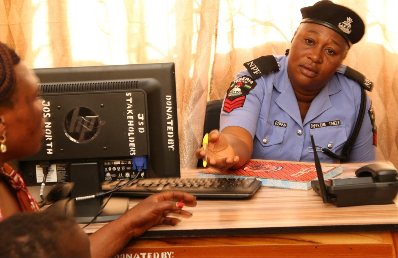In Jos, officer Umele Onyeche hears a local woman’s story at the city’s first police unit dedicated to investigating sexual violence. Police and the community created the unit following a dialogue supported by USIP.