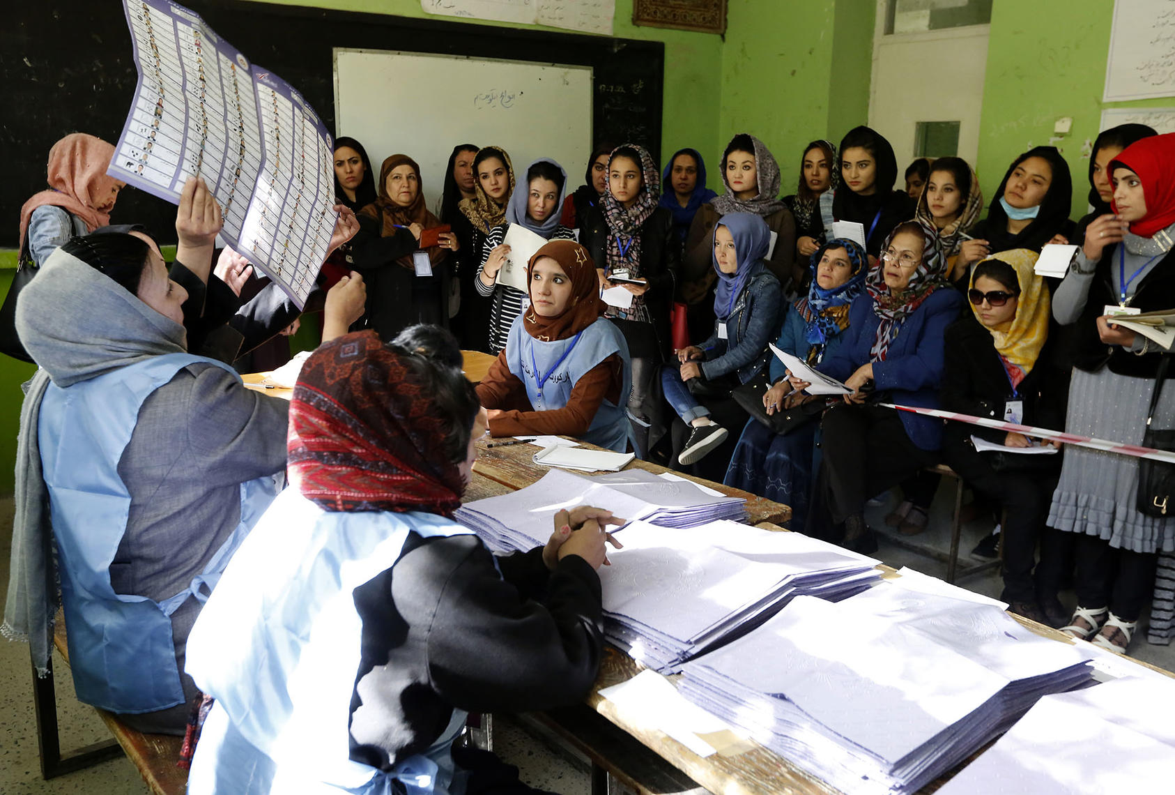 An electoral official examines a ballot in front of election observers during the 2018 parliamentary elections in Kabul, Oct. 21, 2018. (Fardin Waezi/UNAMA)