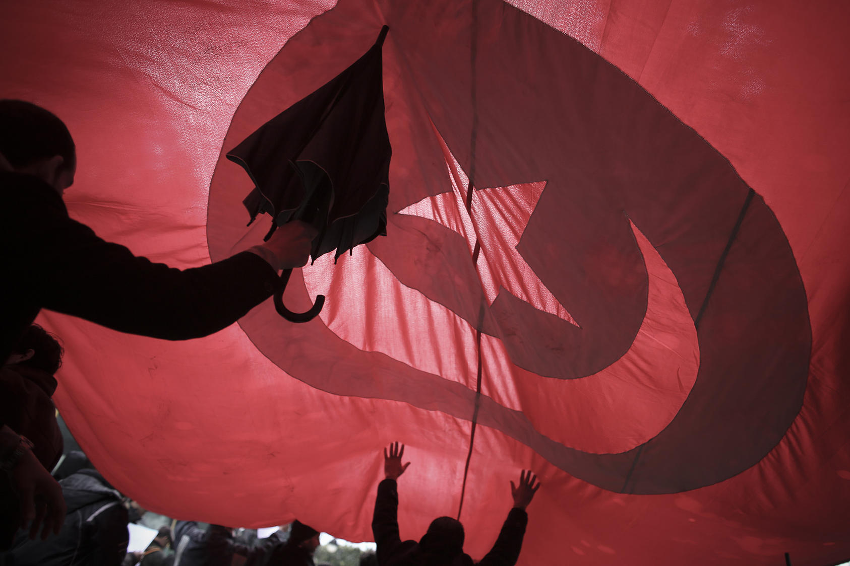 Under a Tunisian flag, government supporters rally in Tunis, Tunisia, Feb. 9, 2013. (Tara Todras-Whitehill/The New York Times)
