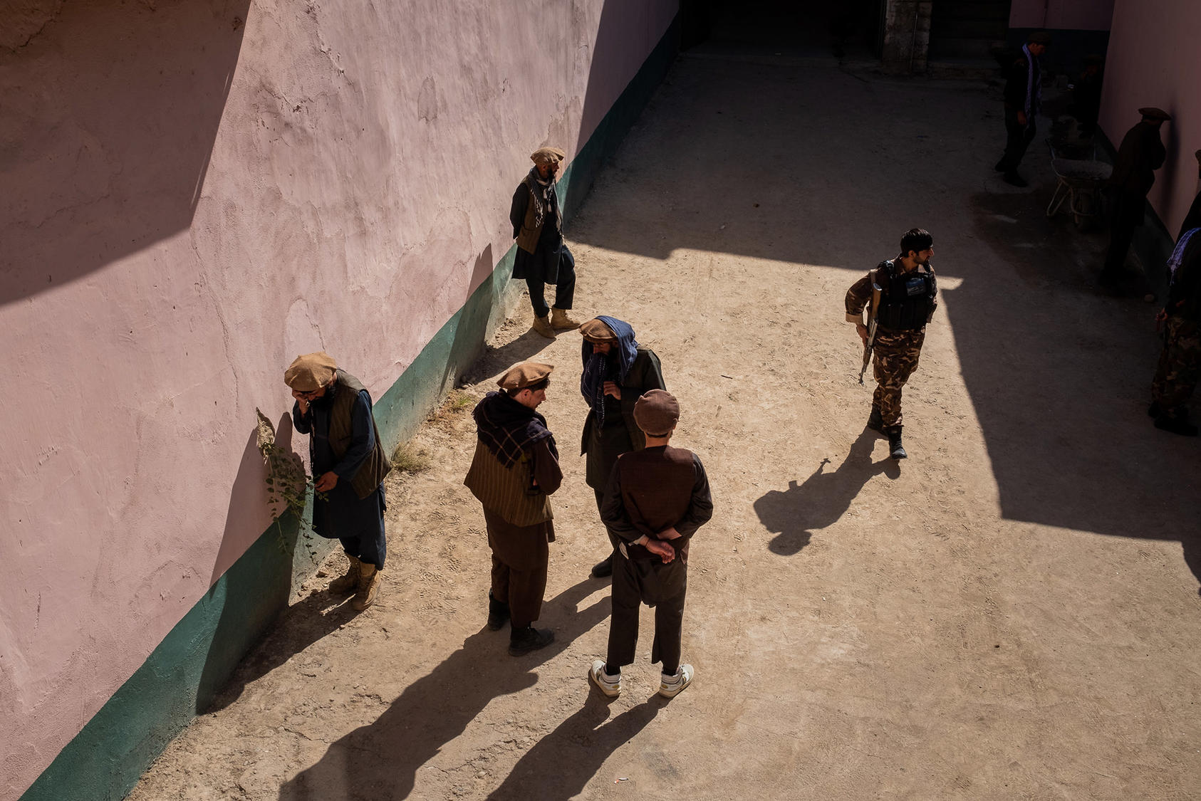 A soldier walks among a group of alleged Taliban fighters at a National Directorate of Security facility in Faizabad in September 2019. The status of prisoners will be a critical issue in future negotiations with the Taliban. (Jim Huylebroek/New York Times)