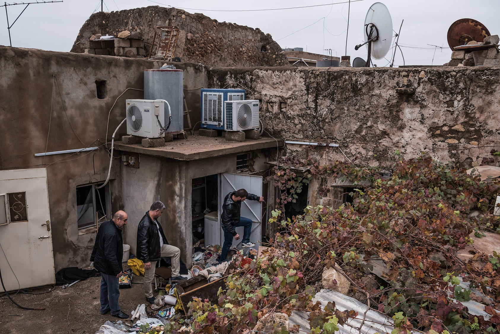 Men from the Al-Saka family check their house after they said they had not been there for two years during Islamic State occupation, in Bartella, a predominantly Christian town in Iraq, Dec. 1, 2016. (Sergey Ponomarev/The New York Times)