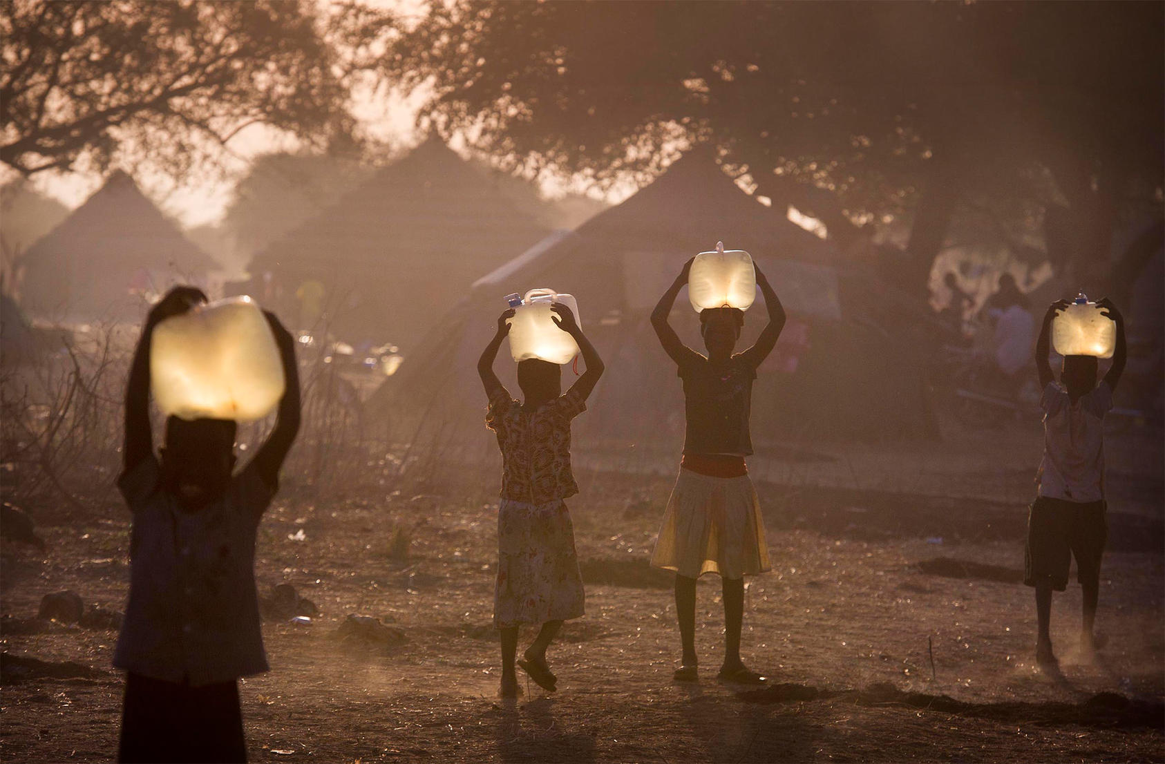 South Sudanese children carry water for their families at sunset in a camp for people displaced by warfare. About 39 percent of South Sudan’s 11 million people have been uprooted amid the country’s violence. (www.geoffpugh.com/Flickr)