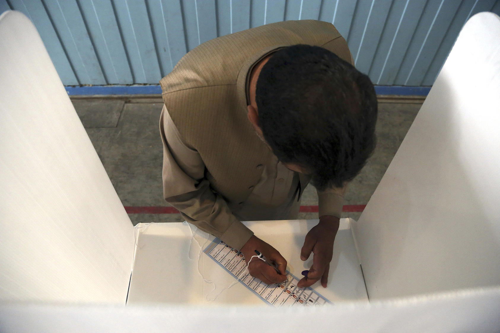 An Afghan man marks a ballot at a polling station in Kabul during the September 28, 2019 presidential election. (AP Photo/Rahmat Gul)