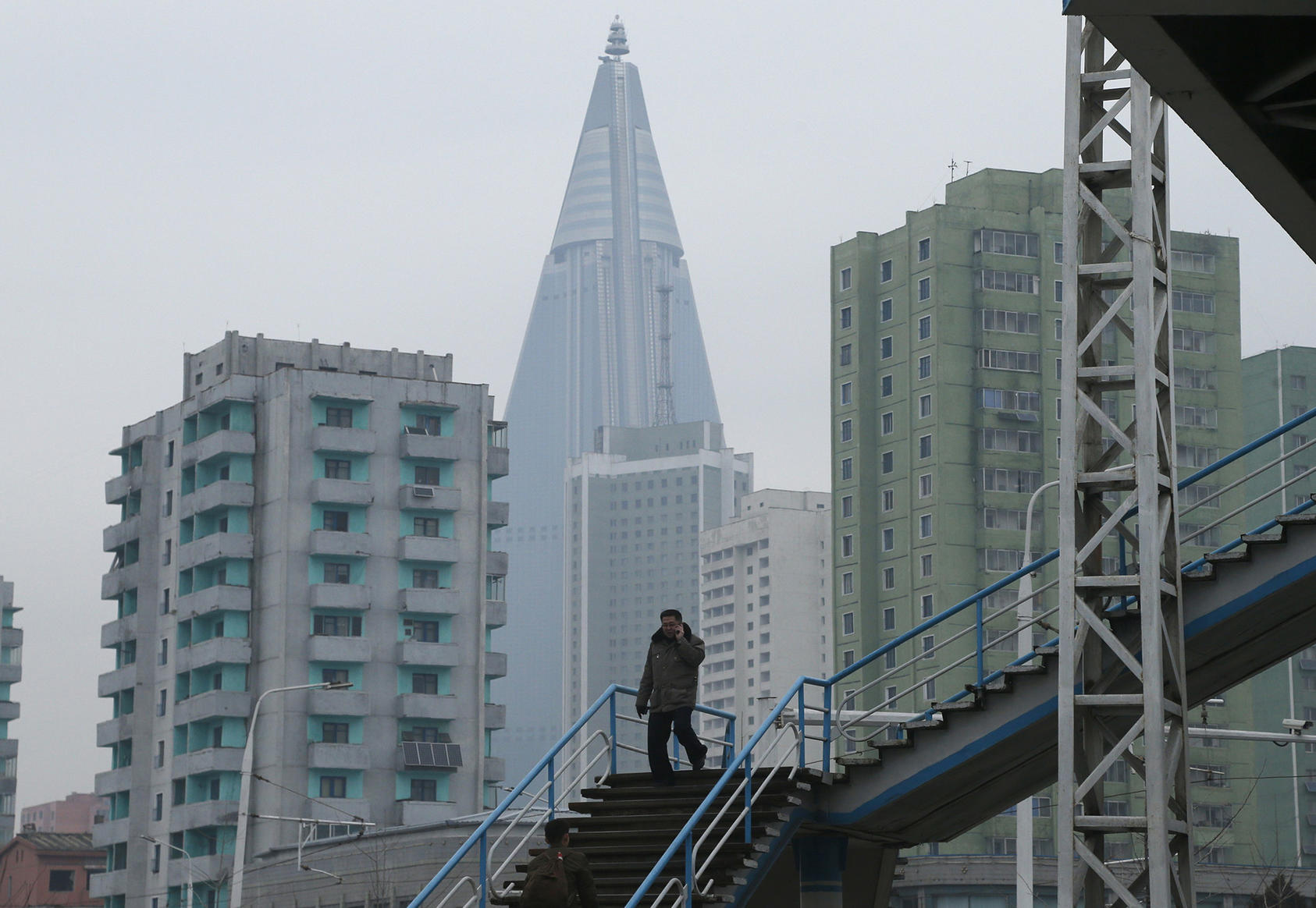 A man talks on his mobile phone while walking in downtown Pyongyang on December 15, 2018. (Photo by Dita Alangkara/AP)
