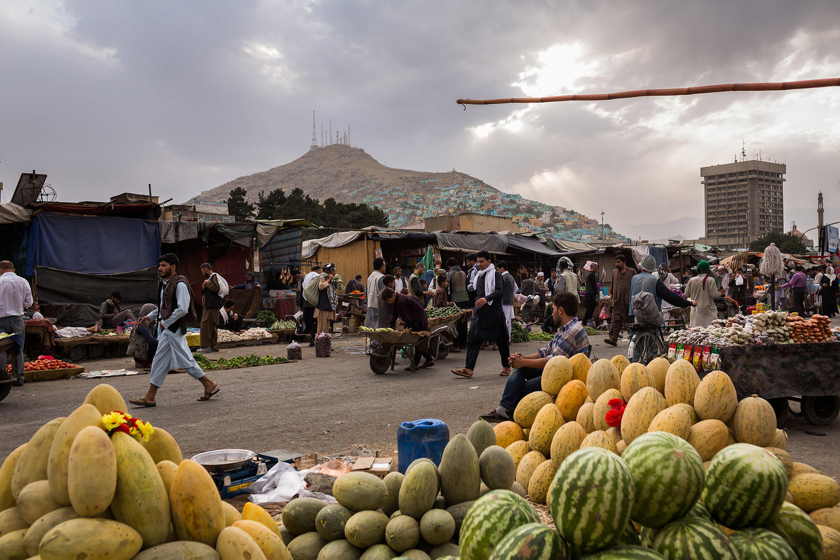 Customers shop for fruits at the retail market along Kabul river in Afghanistan in 2017. (Jim Huylebroek/The New York Times)
