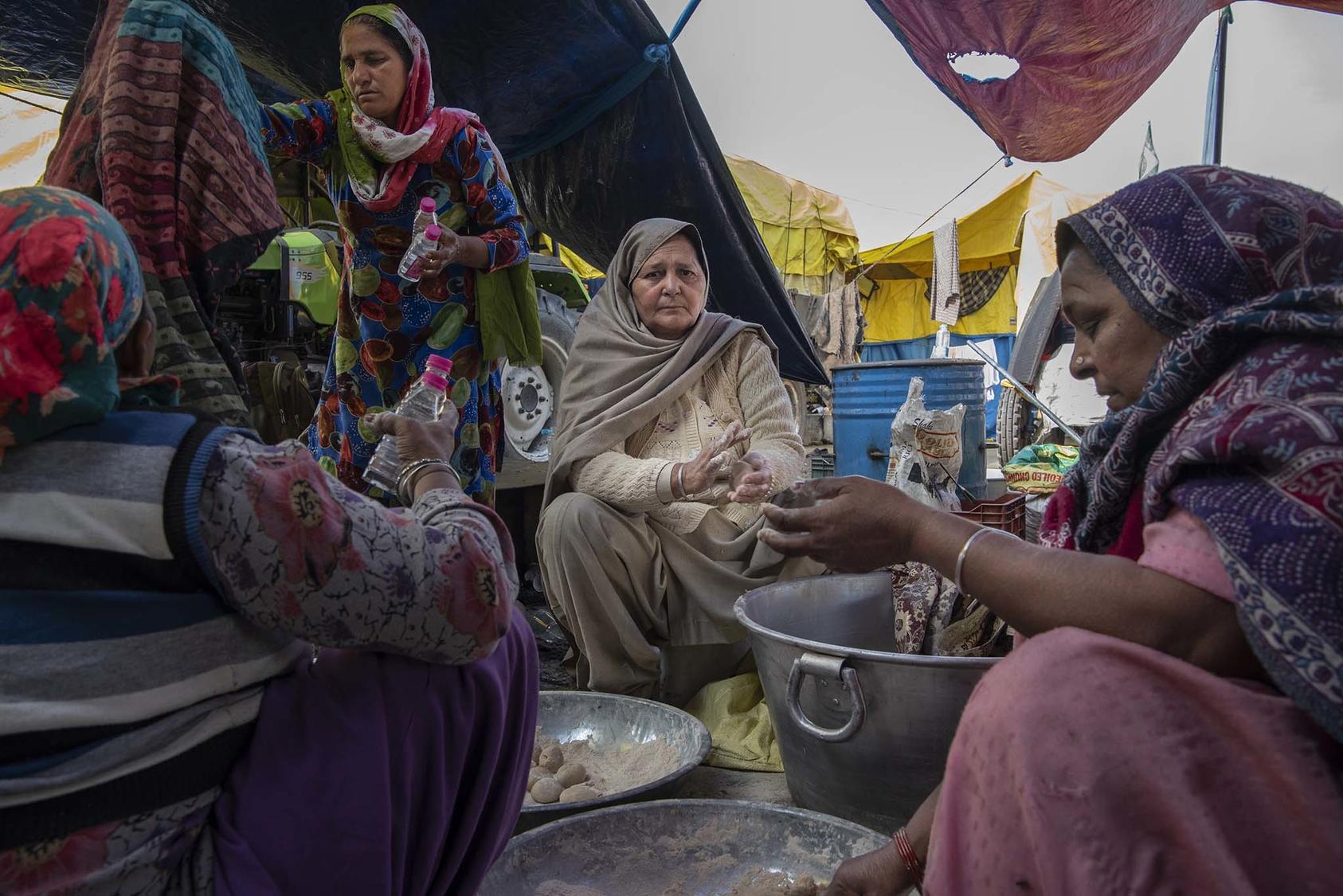 Gurmeet Kaur, center, preparing chapati, in Singhu, India, Jan. 4, 2021. Protesters have created camps around Delhi that are virtual cities unto themselves, using own organizational skills to protest new government farm policies. (Saumya Khandelwal/The New York Times)
