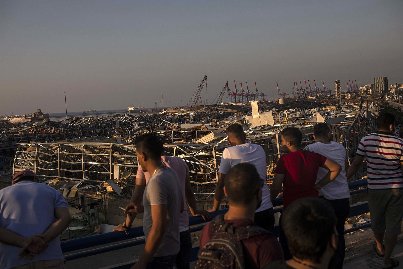People survey the wreckage at the Beirut port, Aug. 6, 2020. In February, a court in Lebanon removed the judge investigating the explosion, adding a delay to the country’s sluggish efforts to determine what happened and ensure accountability. (Diego Ibarra Sanchez/The New York Times)