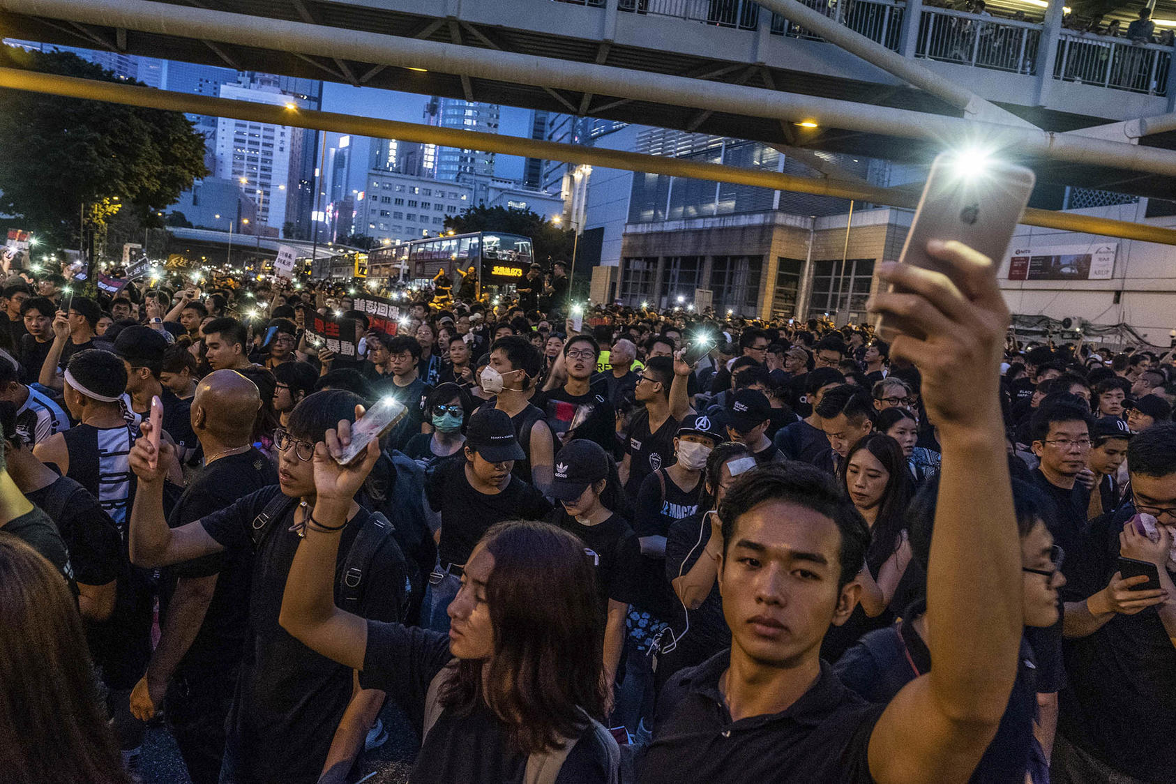 Personas encienden las linternas de sus teléfonos inteligentes en una manifestación en Hong Kong el 16 de junio de 2019 en conmemoración de la muerte de un compañero manifestante. (Fotografía de Lam Yik Fei/New York Times)