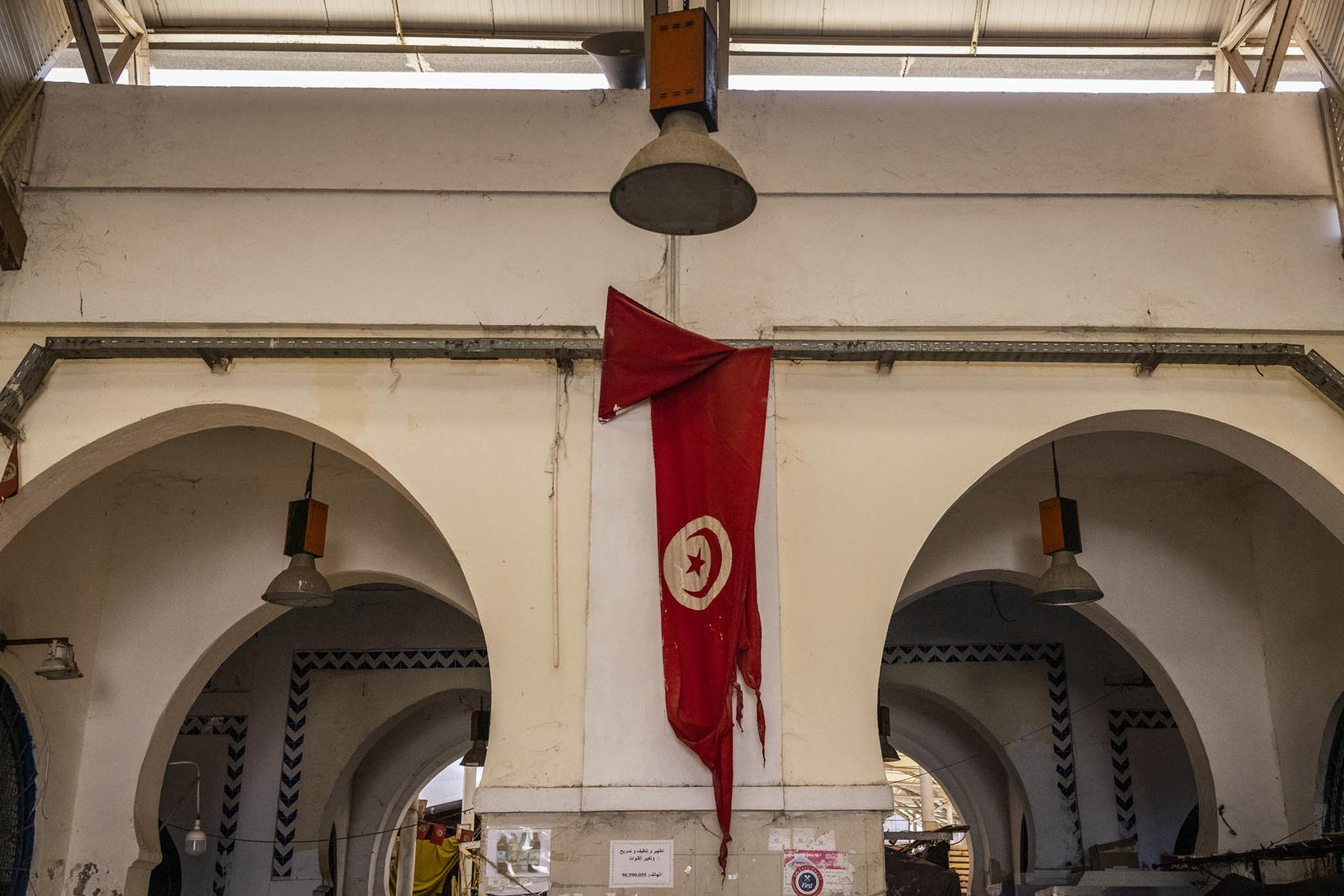 A tattered Tunisian flag at a market in downtown Tunis, Sept. 28, 2021. It’s premature at this point to proclaim an end to Tunisia’s democratic project, but there has been tremendous backsliding over the past year.  (Ivor Prickett/The New York Times)
