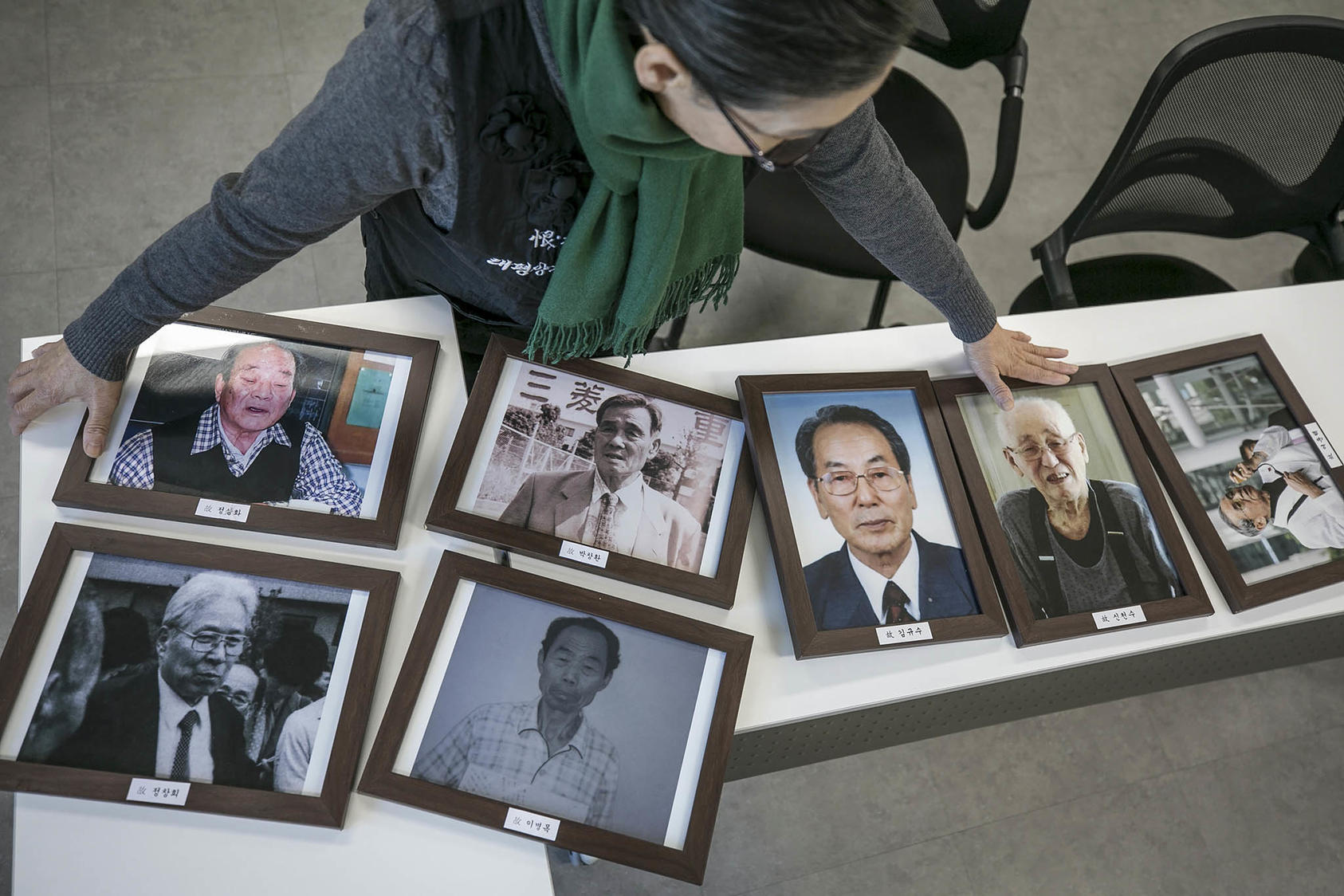Lee Hee-ja, a South Korean activist whose father died as a forced laborer for the Japanese military, displays photos of other forced labor victims in Seoul, South Korea. December 7, 2018. (Jean Chung/The New York Times)