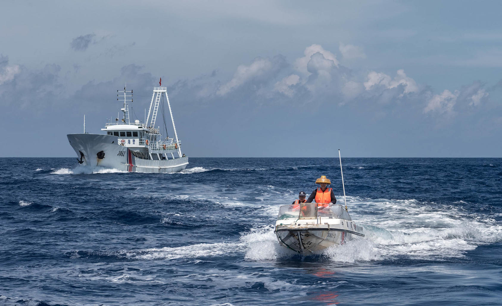 A speedboat launched from a Chinese Coast Guard vessel, in the background, orders the Motoryacht Isla to leave the Scarborough Shoal in the South China Sea. June 18, 2016. (Sergey Ponomarev/The New York Times)