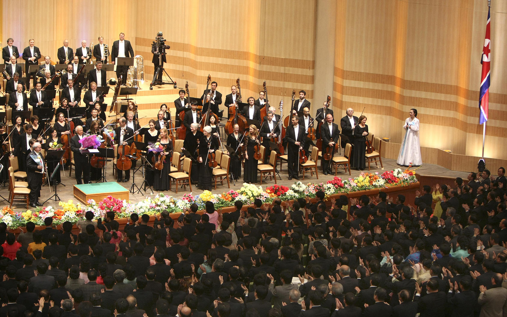 Conductor Lorin Maazel along members of the New York Philharmonic after their concert in Pyongyang, Feb. 26, 2008. The performance marked the first time a major American cultural organization had appeared in North Korea. (Chang W. Lee/The New York Times)