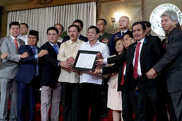 President Rodrigo R. Duterte poses for a photo with the legislators and negotiators in the peace process with the Moro Islamic Liberation Front (MILF), as well as top officials from the Armed Forces of the Philippines and Philippine National Police during the presentation of the Bangsamoro Organic Law (BOL) to the MILF at Malacañan Palace on August 6, 2018. (Philippine News Agency / Wikimedia Commons)