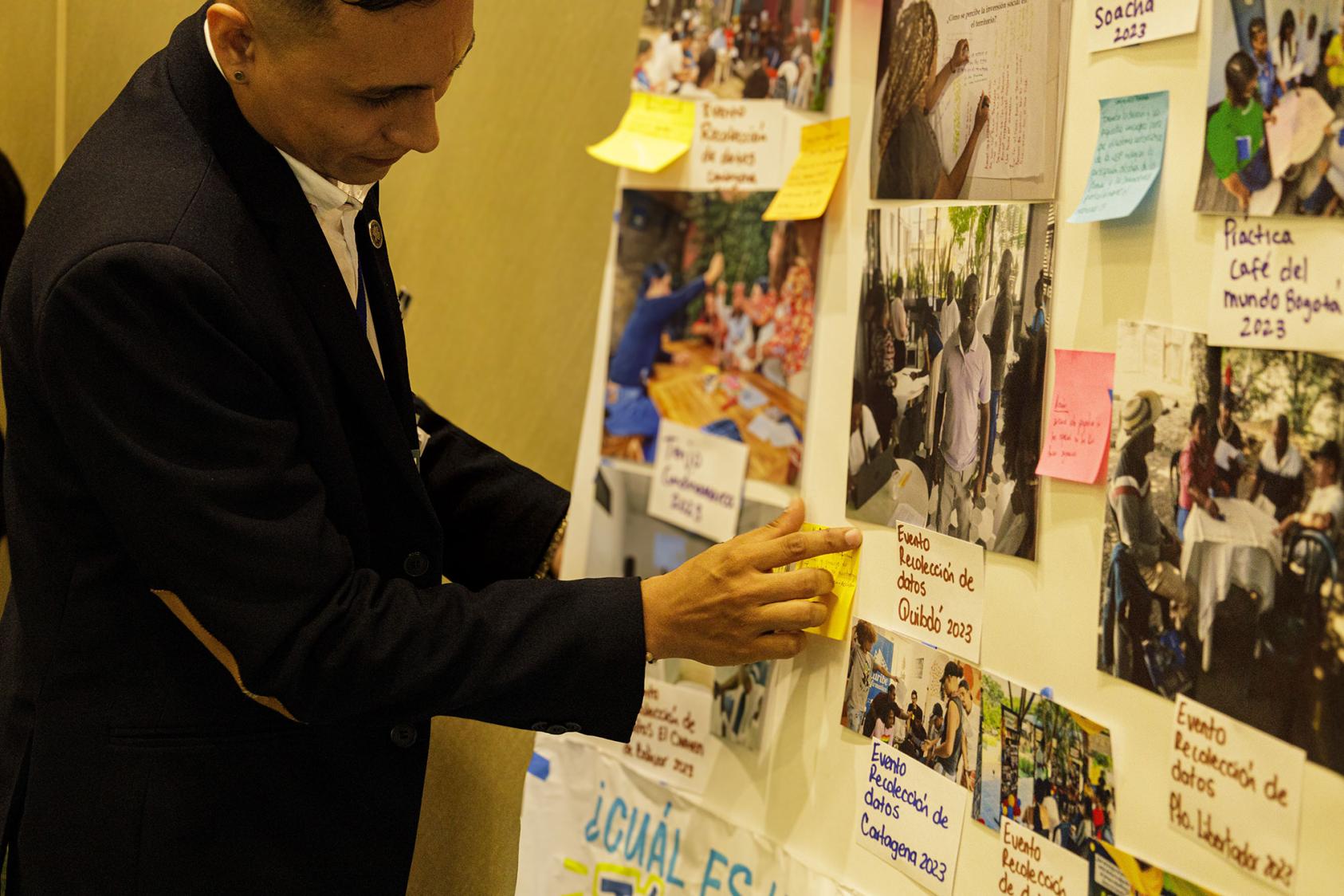 Colombian Youth Researcher, Juan Sebastian Pineda, shows PAR activities through a photo gallery at the National Event in Bogota (February 2024). Photo Credit: Somos CaPAZes