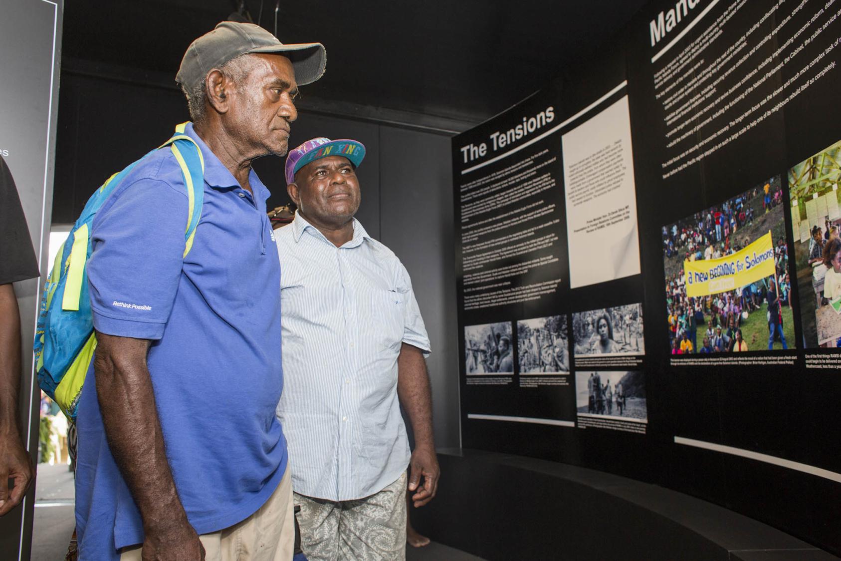 Solomon Islanders visit a gallery detailing the work of the Regional Assistance Mission to Solomon Islands, which helped end the country’s five-year civil conflict. Honiara, Solomon Islands. June 26, 2017. (RAMSI/Flickr)