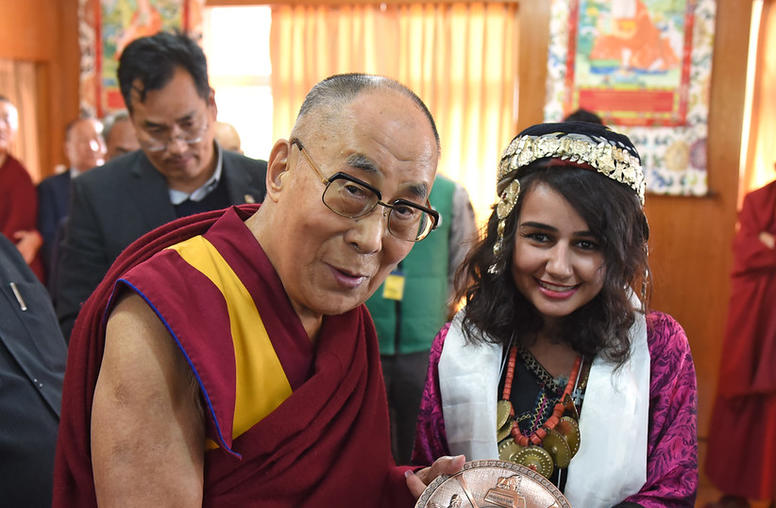 A photo of His Holiness Dalai Lama accepting a gift from Lourd