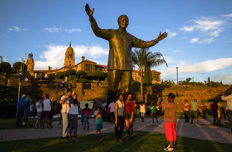 People visit a statue of former South African President Nelson Mandela in Pretoria, South Africa. (Daniel Berehulak/The New York Times)