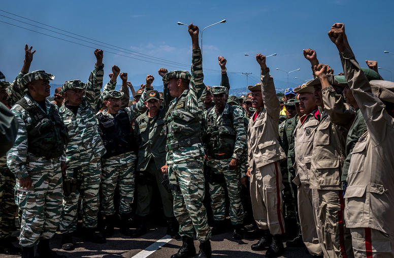 Venezuelan soldiers and militia members stand in formation across the road in leading to The Tienditas Bridge connecting Venezuela with Colombia. (Meridith Kohut/The New York Times)