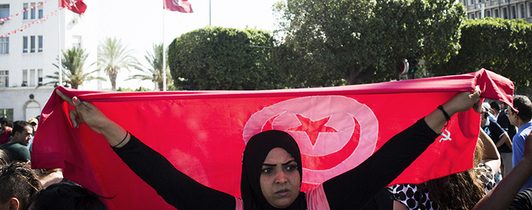 A protester carries a Tunisian flag during a rally after the assassination of Mohamed Brahmi, the leader of the Arab nationalist People's Party, on Avenue Habib Bourguiba in Tunis, Tunisia, July 25, 2013. The killing of Mohamed Brahmi incited protests blaming the ruling party, as the birthplace of the Arab Spring plunged again into crisis. (Gianni Cipriano/The New York Times)