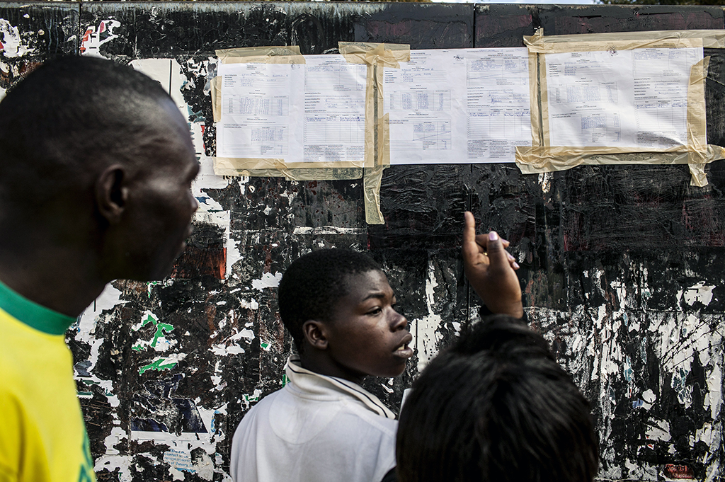 People gather to check election results of a specific polling station in Epworth, a suburb of Harare, Zimbabwe, July 31, 2013. Morgan Tsvangirai, the challenger to Zimbabwe’s longtime president, Robert Mugabe, declared Thursday that the country’s presidential election had been a "huge farce" and called upon international observers to investigate. (Pete Muller/The New York Times)