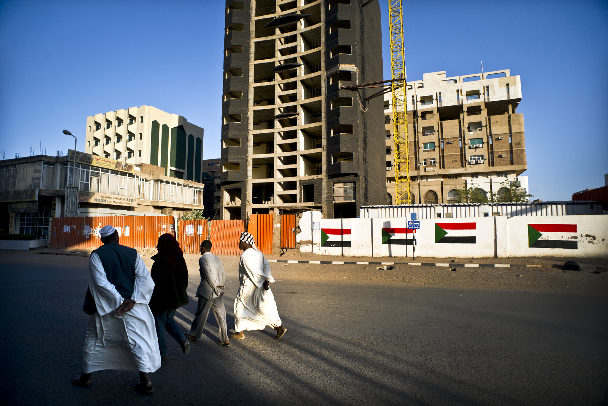 Locals walk pass a paused development project in Khartoum, Sudan, Jan. 26 2012. (Sven Torfinn/The New York Times)