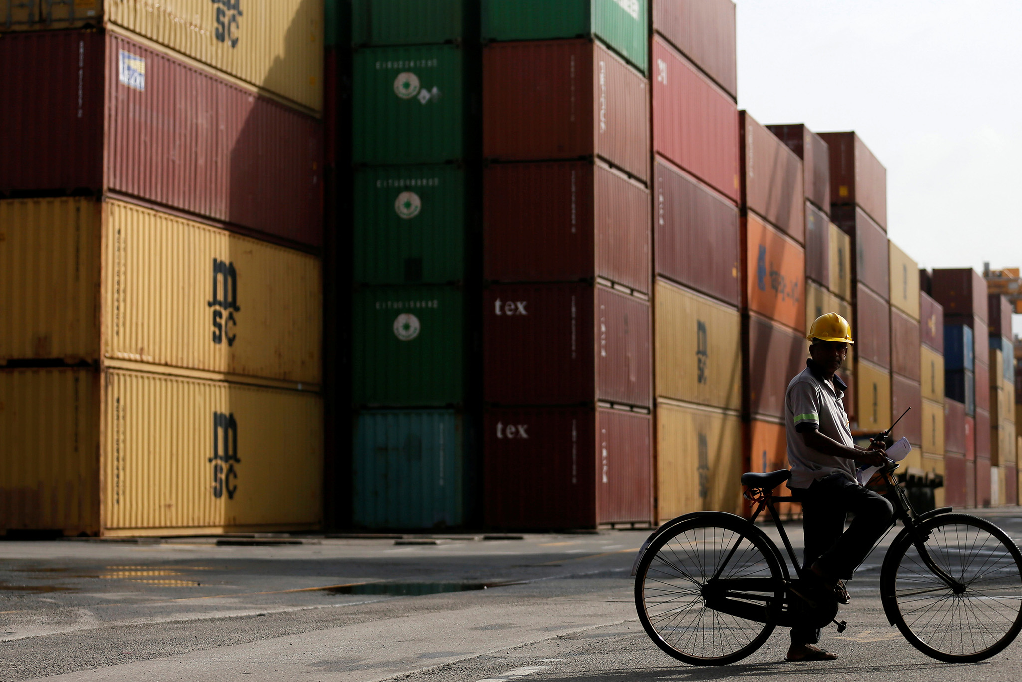 An operator works as shipping containers are seen in the background at the main port in Colombo, Sri Lanka. (Photo by Dinuka Liyanawatte/Reuters)