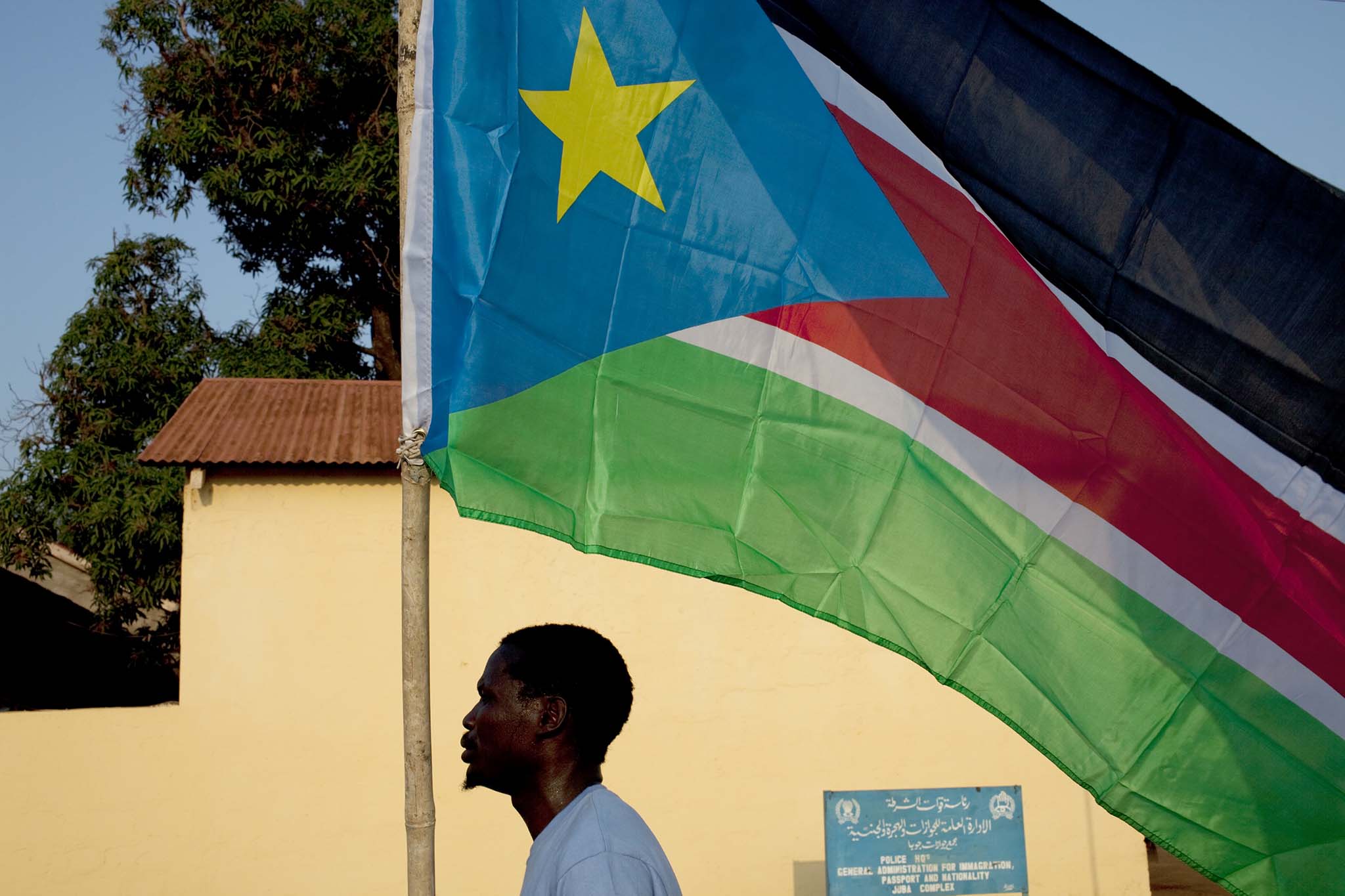 A man carries a southern Sudan flag through the town of Juba, southern Sudan, July 8, 2011. (Tyler Hicks/The New York Times)