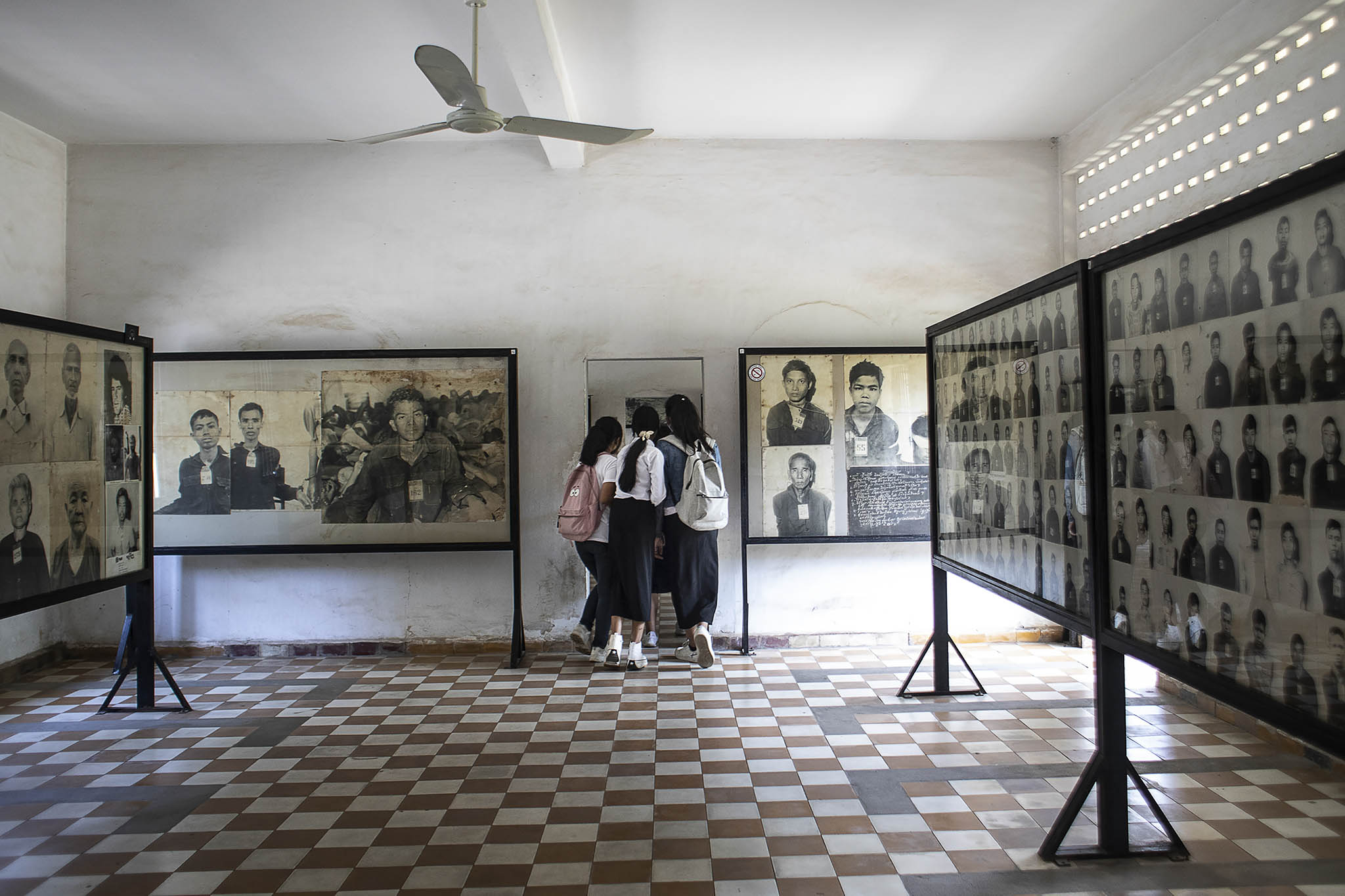 Students make their way through photo displays at the Tuol Sleng Genocide Museum in Phnom Penh, Cambodia, on Saturday, Jan. 22, 2022.. (Nadia Shira Cohen/The New York Times)
