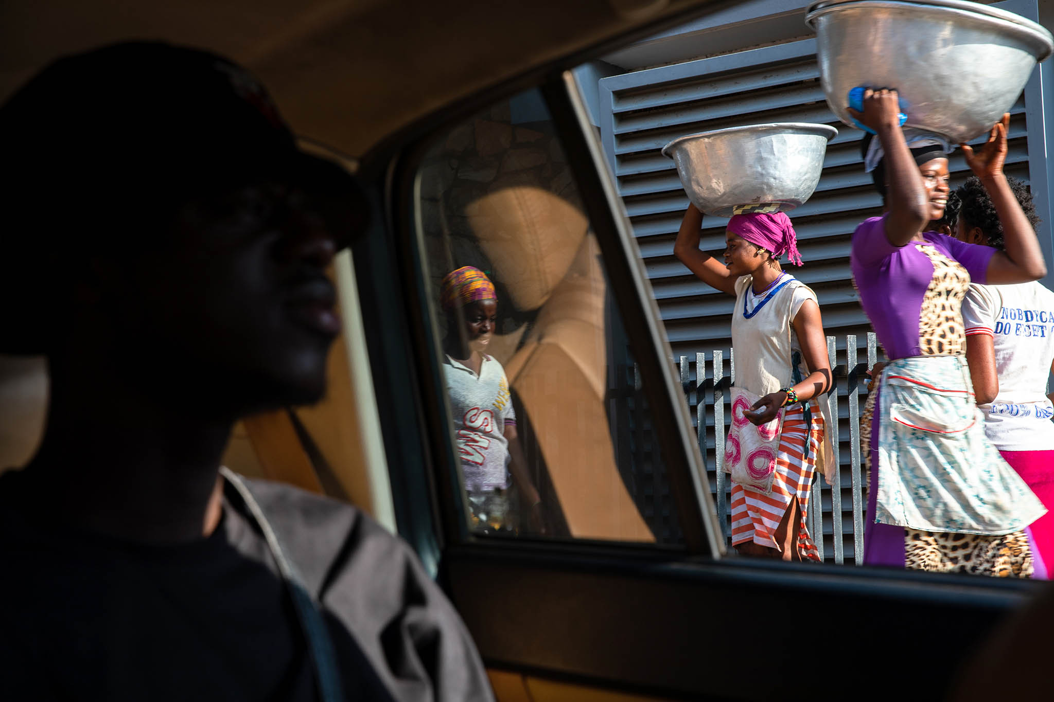 Young women, who balance large bowls on their heads, are paid to carry other people’s shopping bundles in the open-air Makola Market in Accra, Ghana, on November 23, 2019. (Photo by Francis Kokoroko/New York Times)