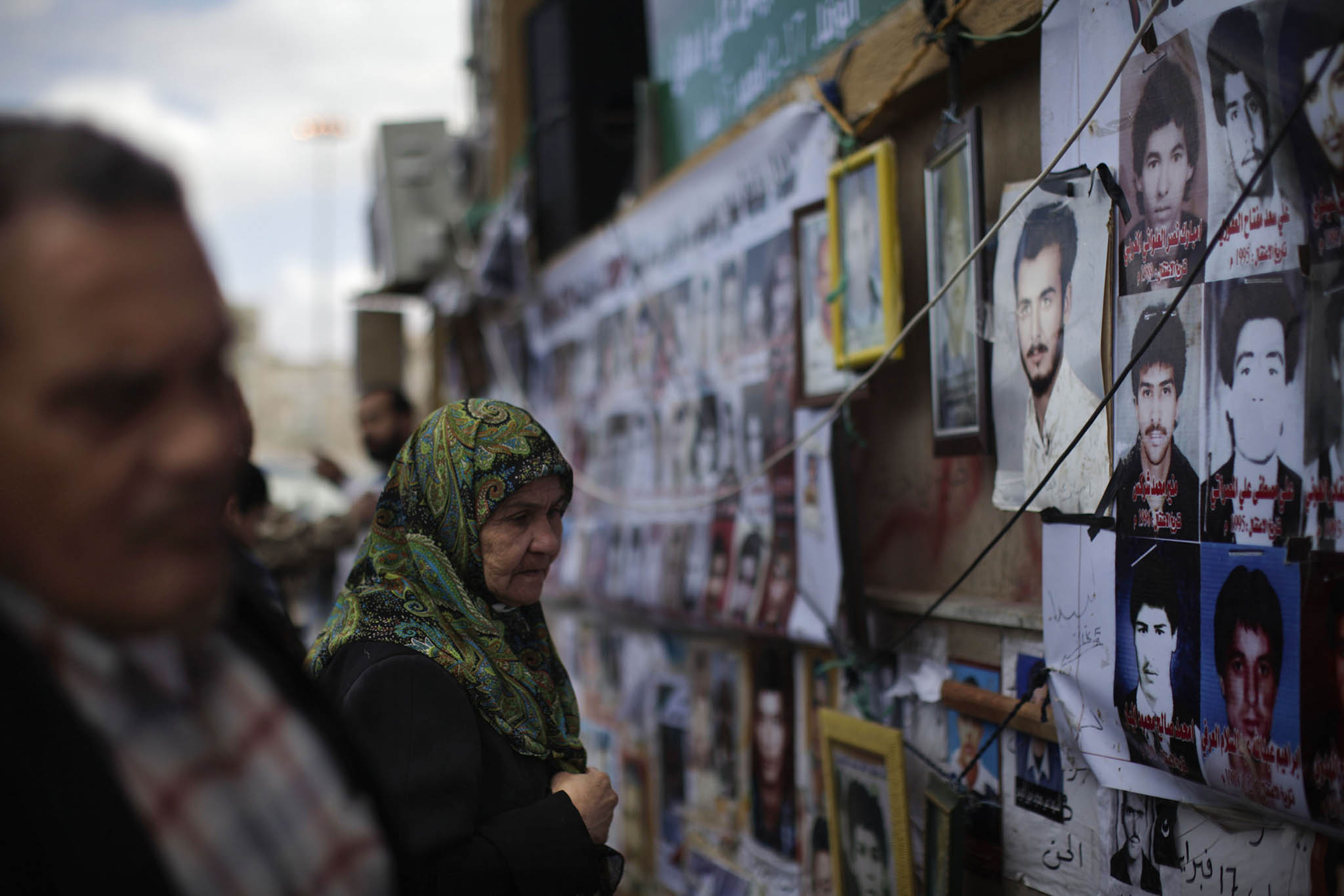 A woman looks at photos of men killed under the regime of Col. Moammar Gadhafi in Benghazi, Libya, on March 10, 2011. (Ed Ou/The New York Times)